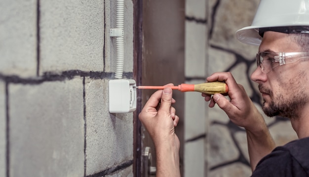 Foto grátis eletricista-técnico masculino, conecta o equipamento a uma ferramenta