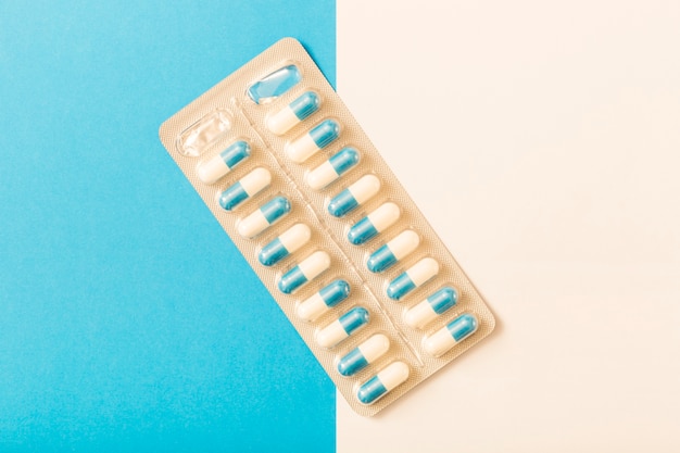 Foto grátis embalagem de cápsulas em fundo branco e azul