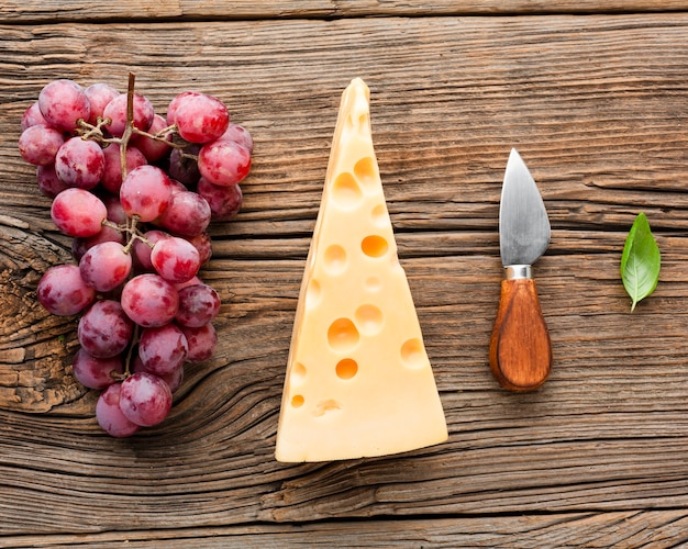 Foto grátis emmental de uvas planas e faca de queijo