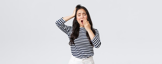 Foto grátis emoções de pessoas de estilo de vida e conceito casual mulher cansada sonolenta trabalhando até tarde no escritório fecha os olhos e boceja quer ir mal menina asiática acordou cedo precisa de suporte de café fundo branco