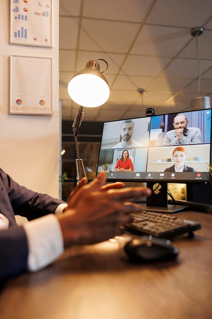 Foto grátis empreendedor discutindo estatísticas financeiras com equipe remota durante conferência de reunião de videoconferência on-line. diversos funcionários corporativos trabalhando horas extras no relatório de crescimento da empresa no escritório de startup