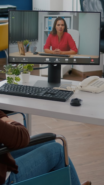 Foto grátis empreendedor imobilizado conversando com um colega de trabalho durante videoconferência