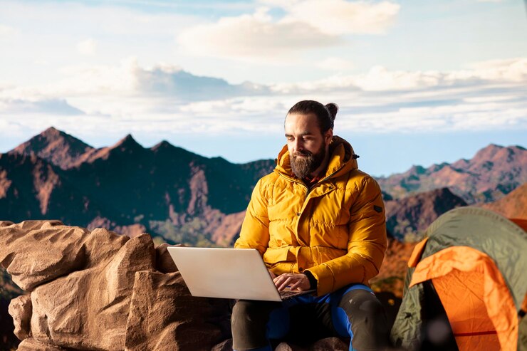 Foto grátis empreendedor on-line moderno com dependência de tecnologia no topo de uma montanha