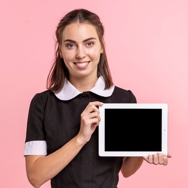 Empregada doméstica de vista frontal segurando um tablet