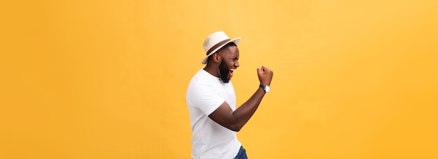 Empregado afro-americano jovem e bonito se sentindo animado gesticulando ativamente mantendo os punhos cerrados e