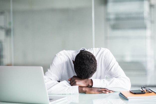 Empregado cansado com roupa formal adormece após longas horas de trabalho no escritório