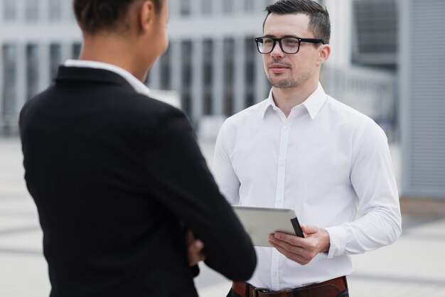 Empregado com óculos, olhando para o colega