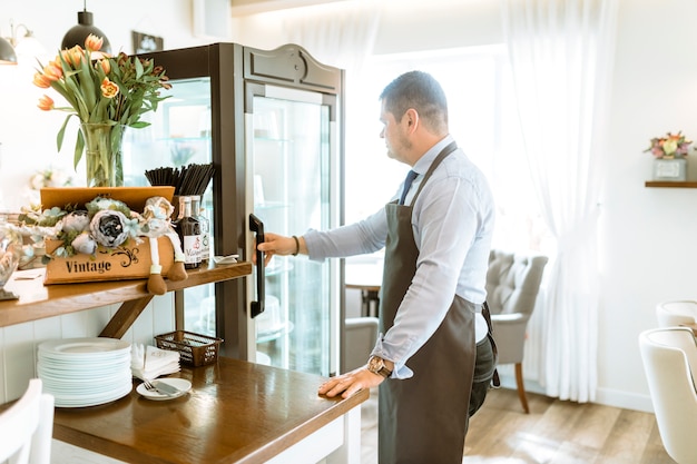 Foto grátis empregado de bar em frente a geladeira