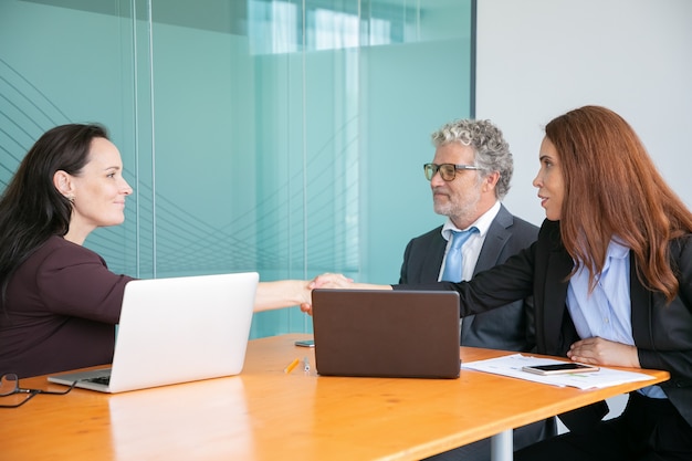 Empregadores de meia-idade de sucesso sentados e apertando a mão