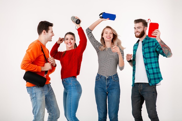 Empresa jovem hipster de amigos se divertindo juntos sorrindo ouvindo música em alto-falantes sem fio dançando rindo fundo branco estúdio isolado em roupa elegante colorida