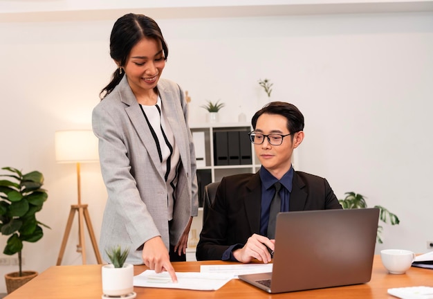 Foto grátis empresária asiática sorridente mostrando relatório de documento para seu gerente durante uma reunião no escritório.