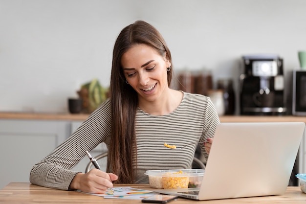 Empresária com fome comendo e lição de casa