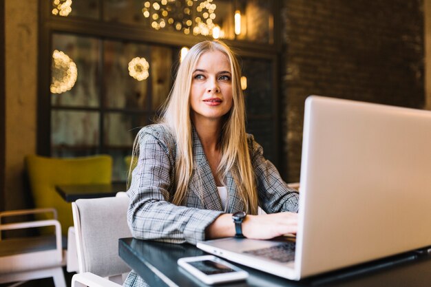 Empresária elegante com laptop na mesa