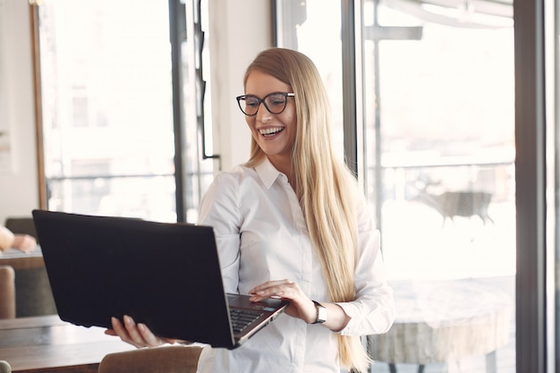 Empresária em pé no escritório com um laptop