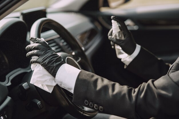 Empresária em uma máscara negra, sentado dentro de um carro