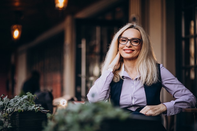 Foto grátis empresária idosa sentada do lado de fora do café