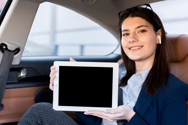 Empresária morena mostrando um tablet