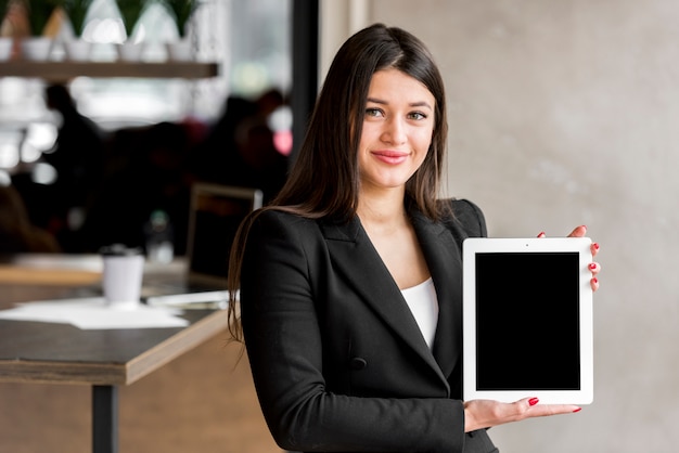Empresária morena mostrando um tablet