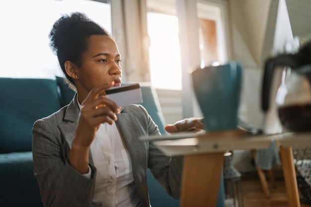 Foto grátis empresária negra usando computador e cartão de crédito ao comprar na internet em casa