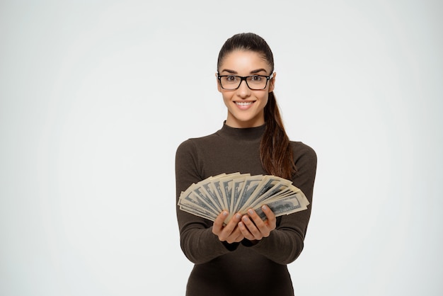 Empresária segurando dinheiro e sorrindo