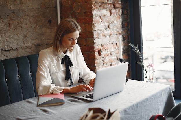 Empresária, sentado à mesa com um laptop