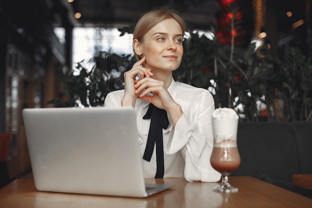 Empresária, sentado à mesa com um laptop