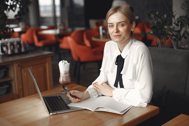 Empresária, sentado à mesa com um laptop