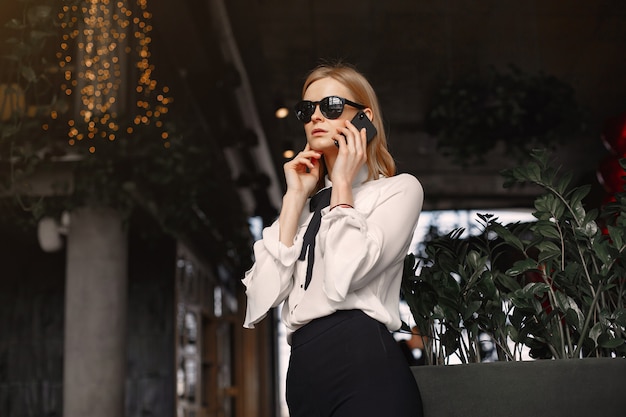 Empresária, sentado à mesa com um telefone