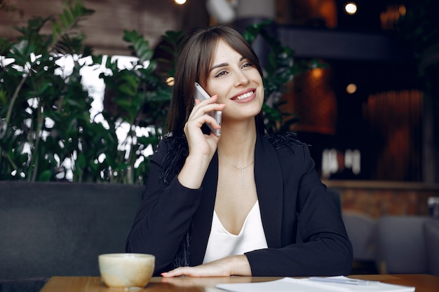 Foto grátis empresária, sentado à mesa em um café e trabalhando