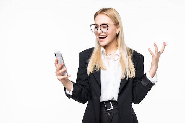 Empresária sorridente usando smartphone sobre parede cinza.