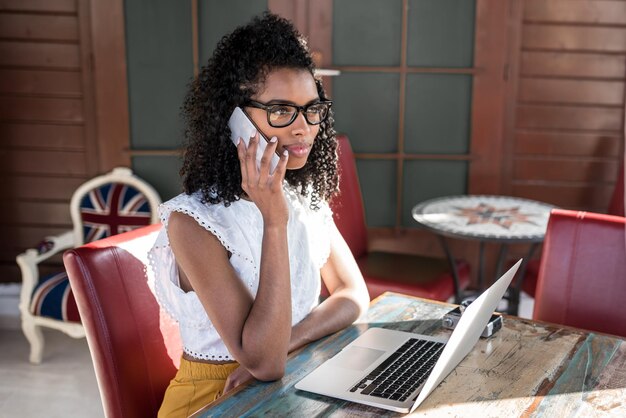 Empresária, trabalhando em casa, no telefone celular