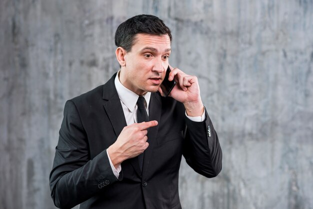 Empresário adulto irritado falando no telefone