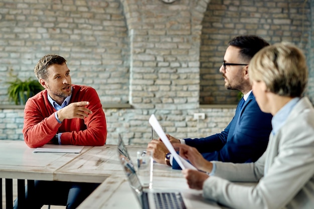 Foto grátis empresário adulto médio se comunicando com a equipe de recursos humanos durante uma entrevista de emprego no escritório