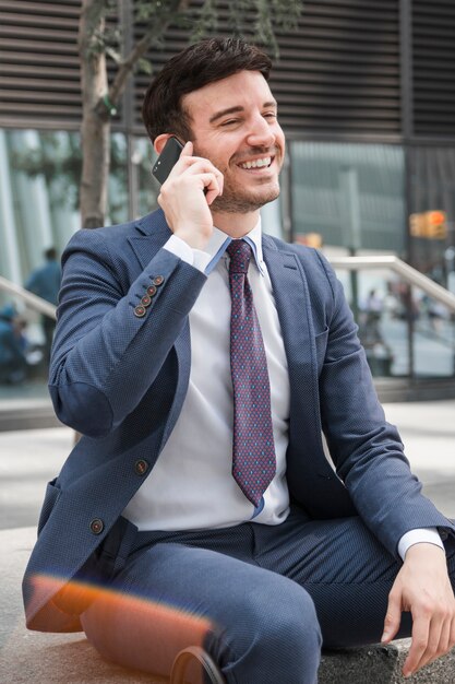 Empresário alegre falando no smartphone