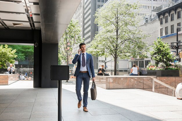 Empresário andando para o trabalho e falando no telefone