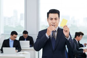 Empresário asiático mostrando cartão amarelo