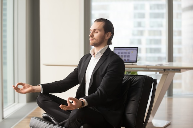 Empresário bem sucedido, meditando no local de trabalho