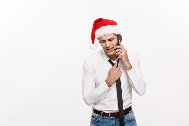 Empresário bonito estressante falando sério no telefone no dia de Natal.