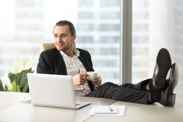 Empresário com café imagina feliz futuro