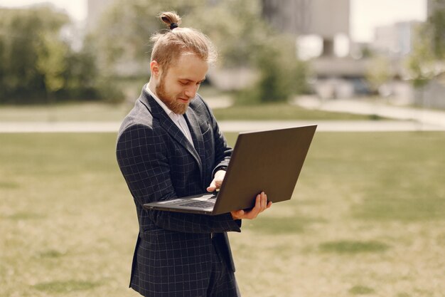 Empresário com laptop em uma cidade de verão