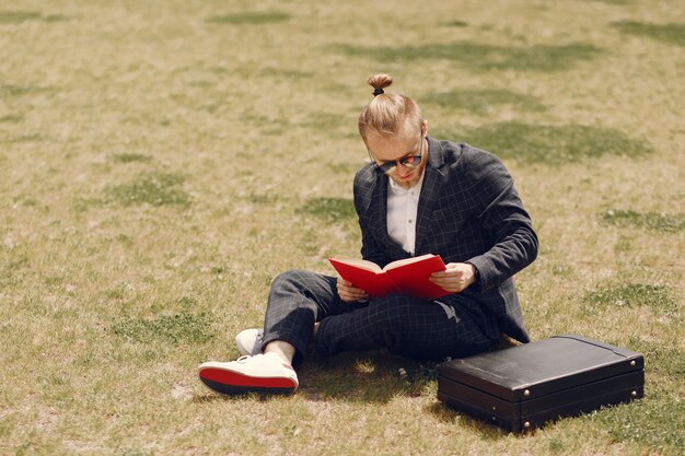 Empresário com livro sentado em uma cidade de verão