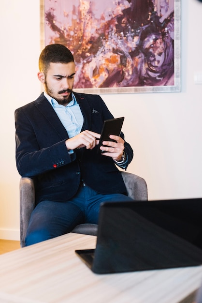 Foto grátis empresário com tablet no laptop