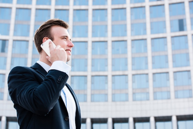 Empresário de baixo ângulo falando ao telefone