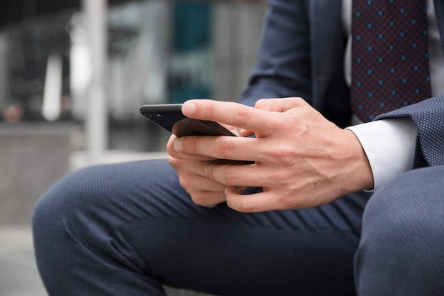 Empresário de colheita navegando smartphone