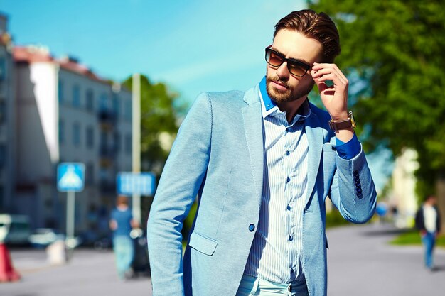 Empresário de terno azul, usando óculos escuros na rua