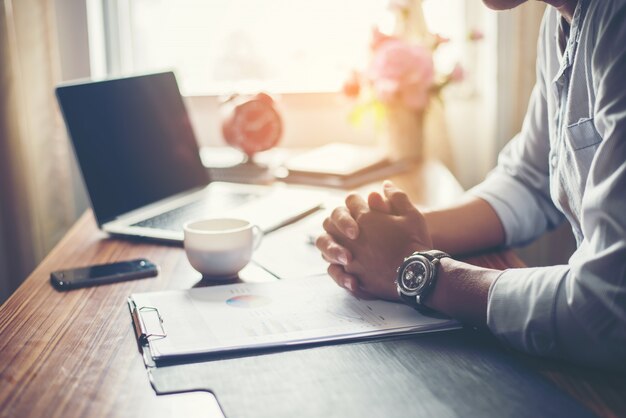 Empresário de trabalho em sua mesa com uma xícara de café no escritório.