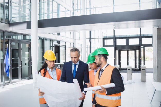 Empresário discutindo na planta com arquitetos