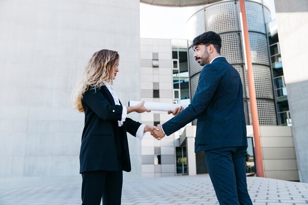 Empresário e empresária apertando as mãos