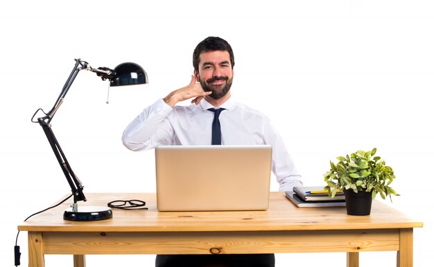 Empresário em seu escritório fazendo gesto de telefone