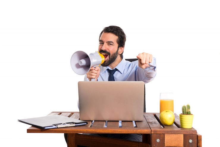 Foto grátis empresário em seu escritório gritando por megafone